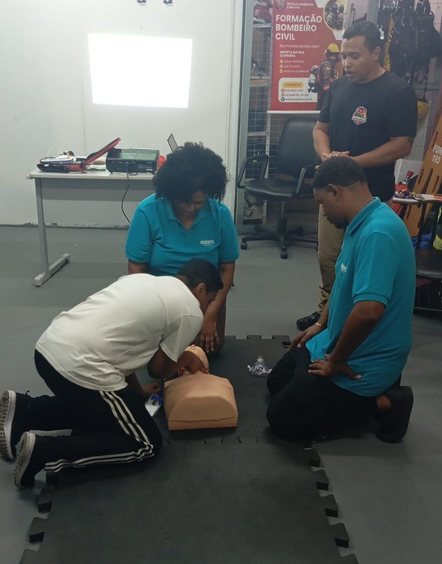 Participantes praticando reanimação cardiopulmonar em manequim